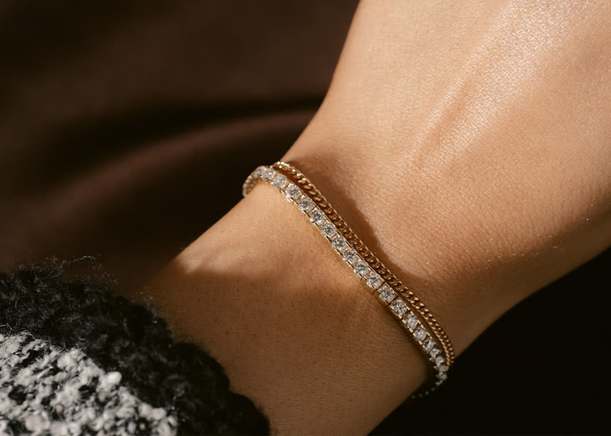Delicate curb chain bracelet in 18K gold paired with a 5.00 carat tennis bracelet in 18K gold, from VANBRUUN